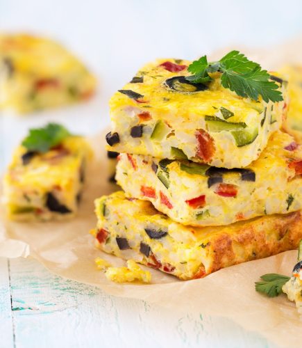 Homemade vegetarian rice frittata with zucchini, bell pepper and olives